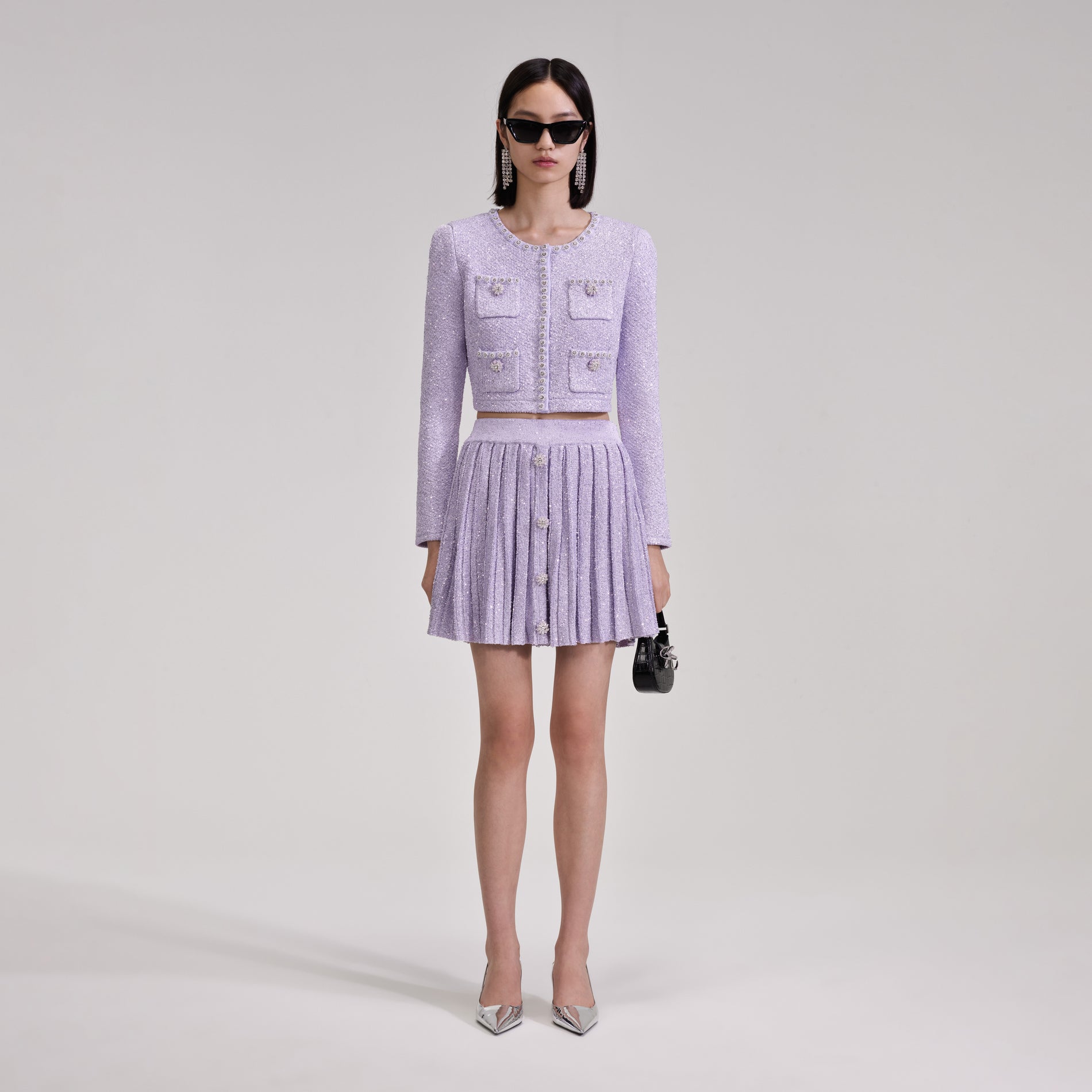 A woman wearing the Lilac Sequin Pleated Knit Skirt