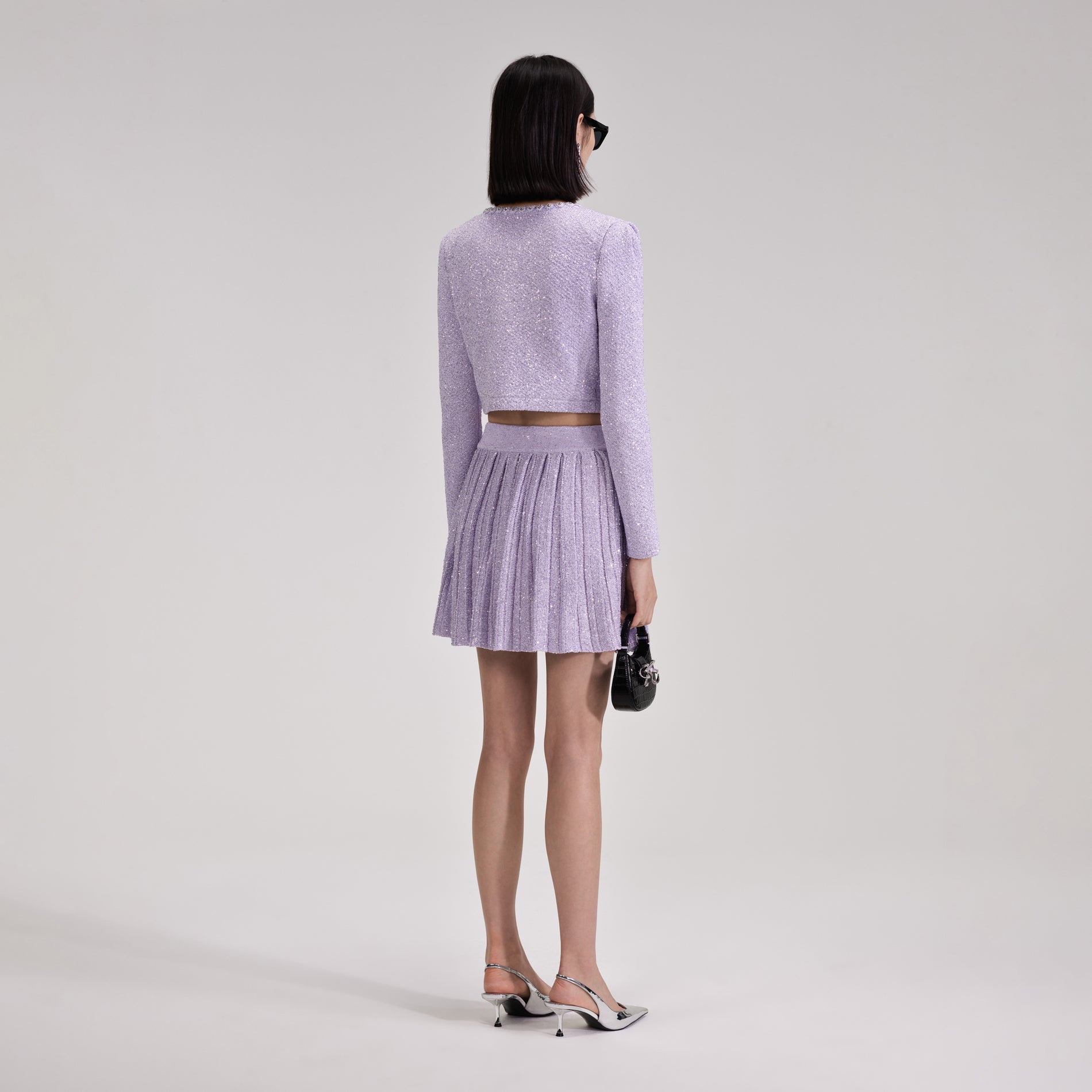 A woman wearing the Lilac Sequin Pleated Knit Skirt
