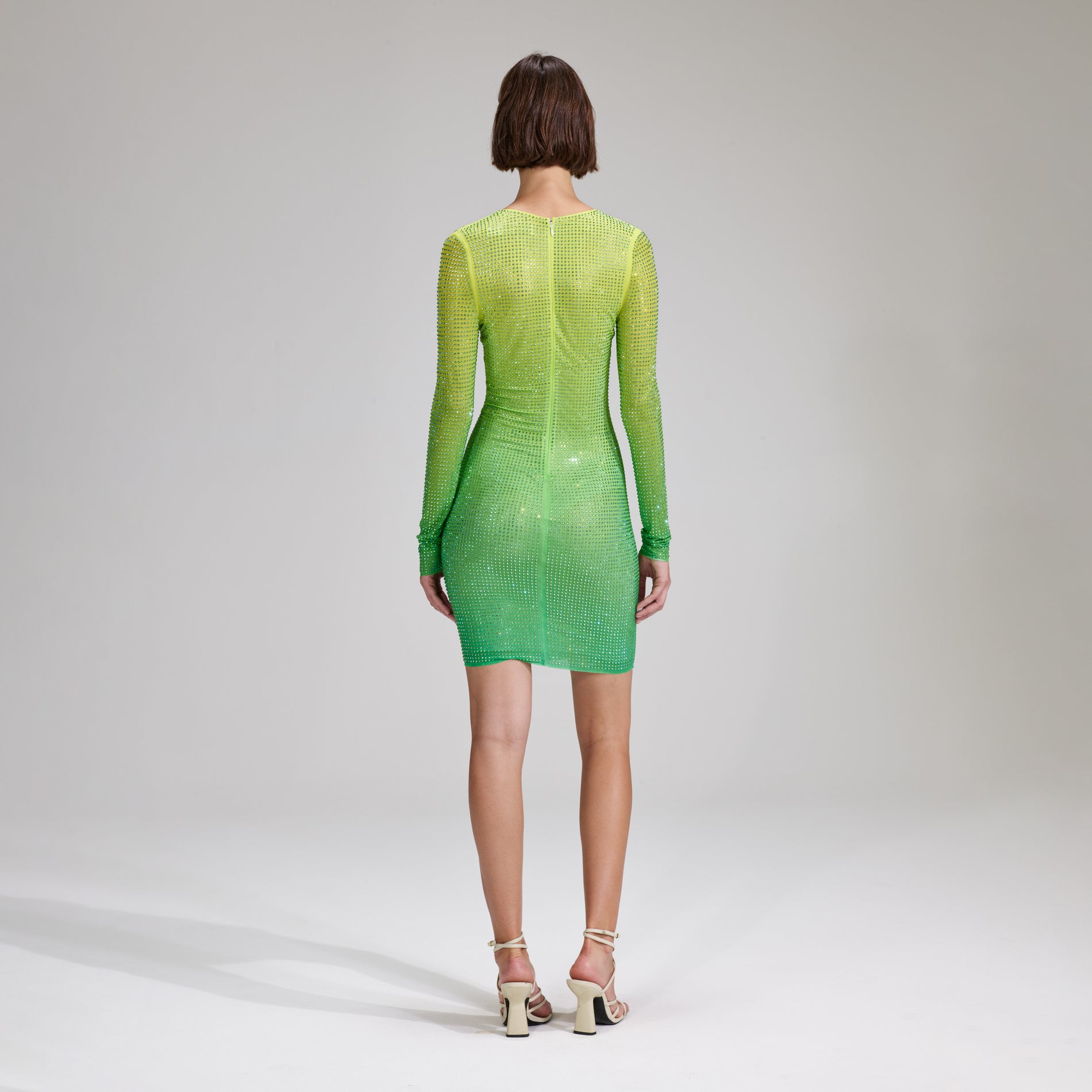 A woman wearing the Green Rhinestone Mesh Keyhole Mini Dress