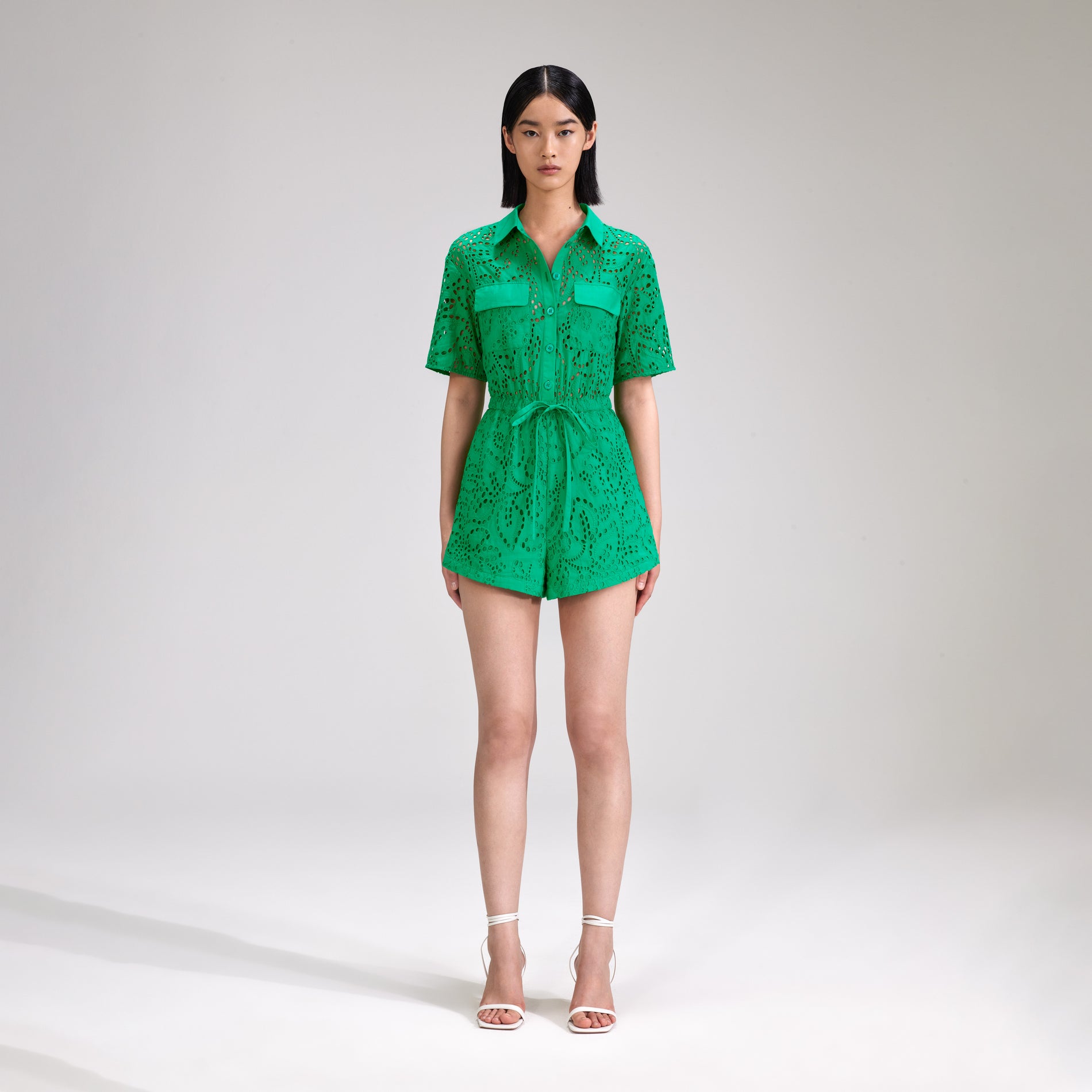A woman wearing the Green Broderie Playsuit