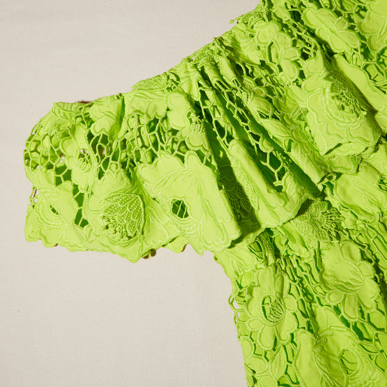 A close up of the fabric for the Green Lace Off Shoulder Mini Dress