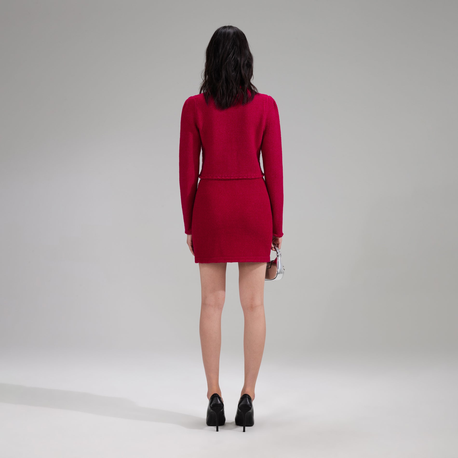 A woman wearing the Red Melange Knit Button Mini Skirt