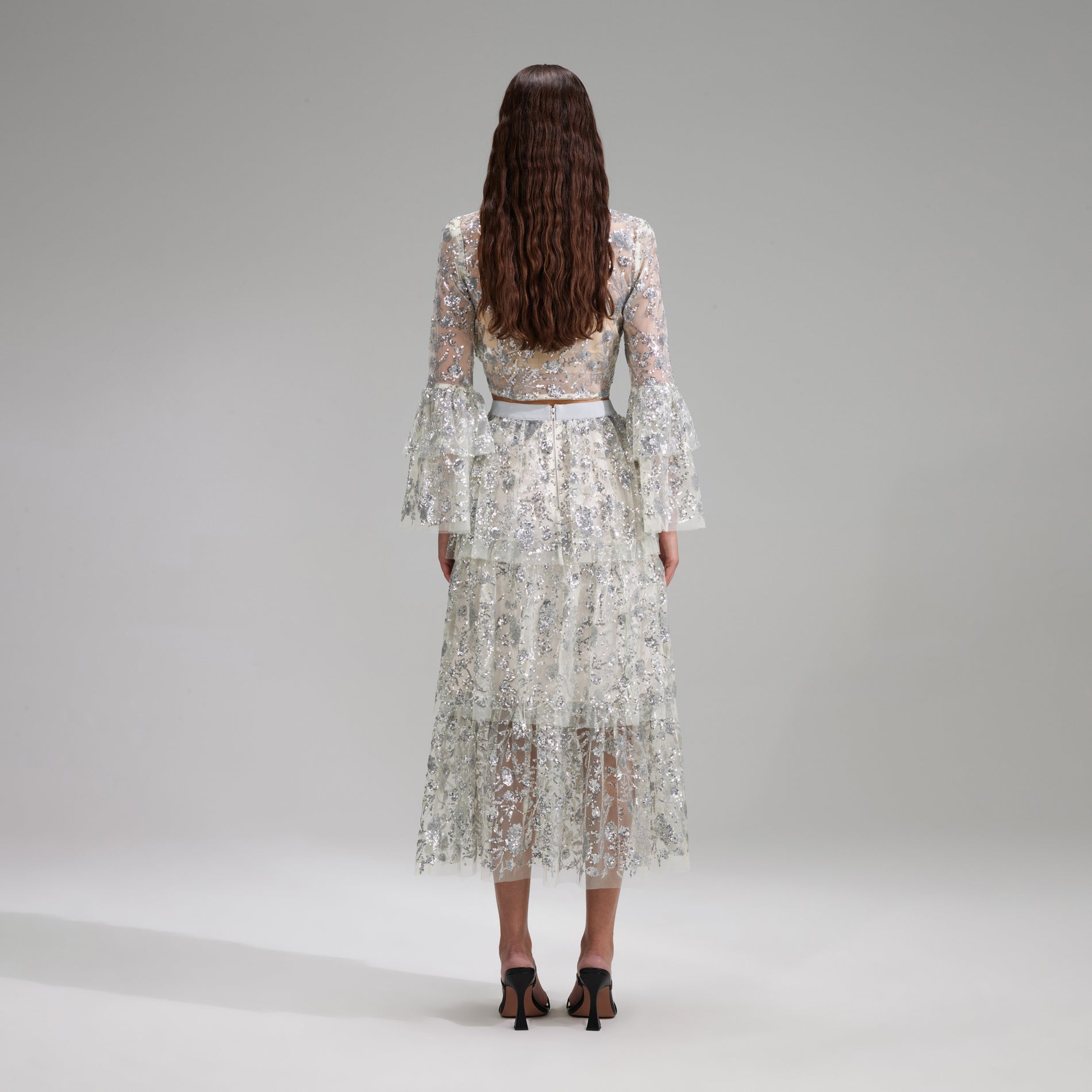 A woman wearing the Champagne Sequinned Tiered Midi Skirt