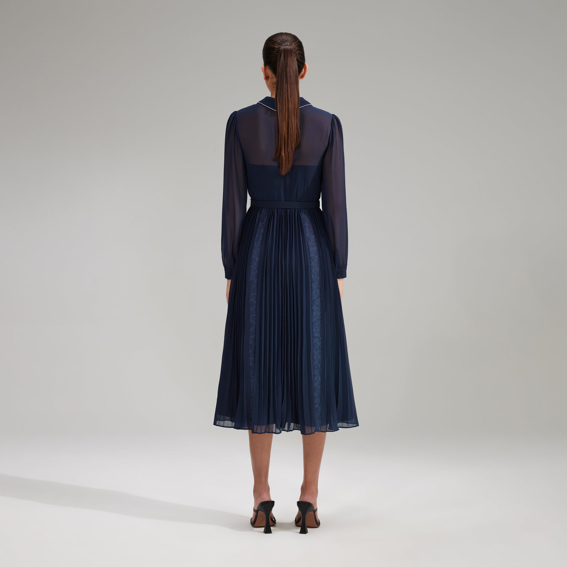 A woman wearing the Navy Pleated Diamante Detail Midi Dress