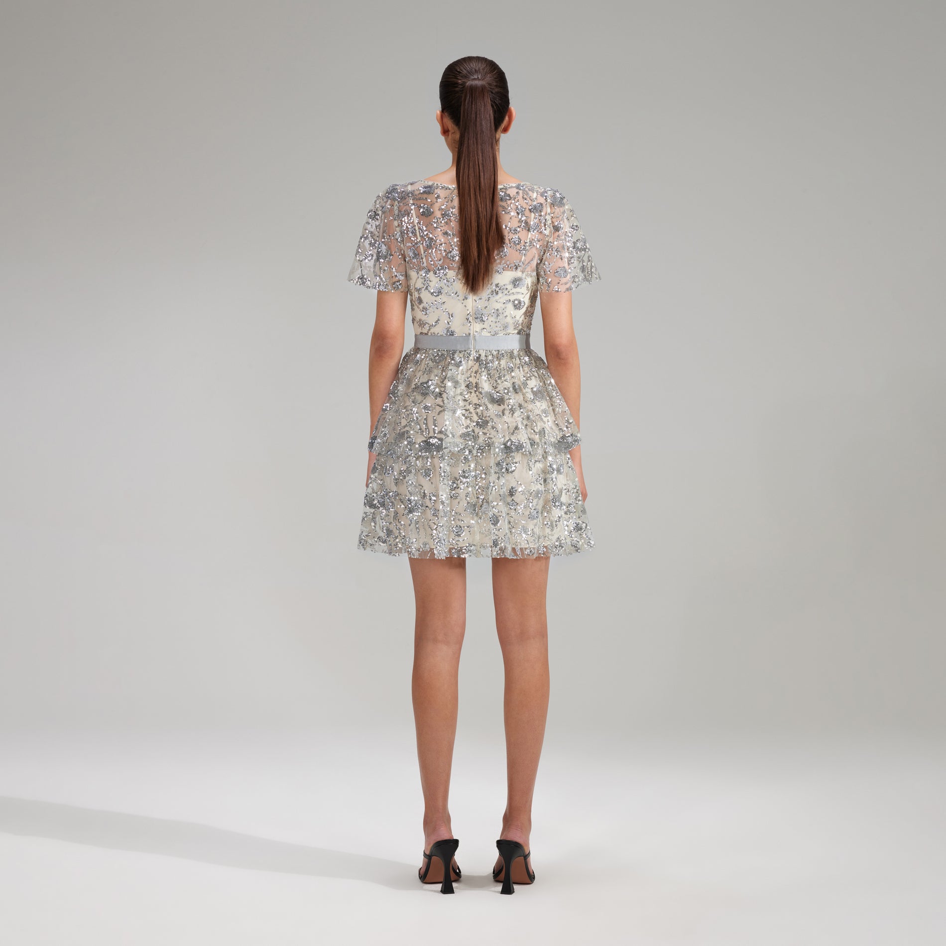 A woman wearing the Champagne Sequinned Tiered Mini Dress