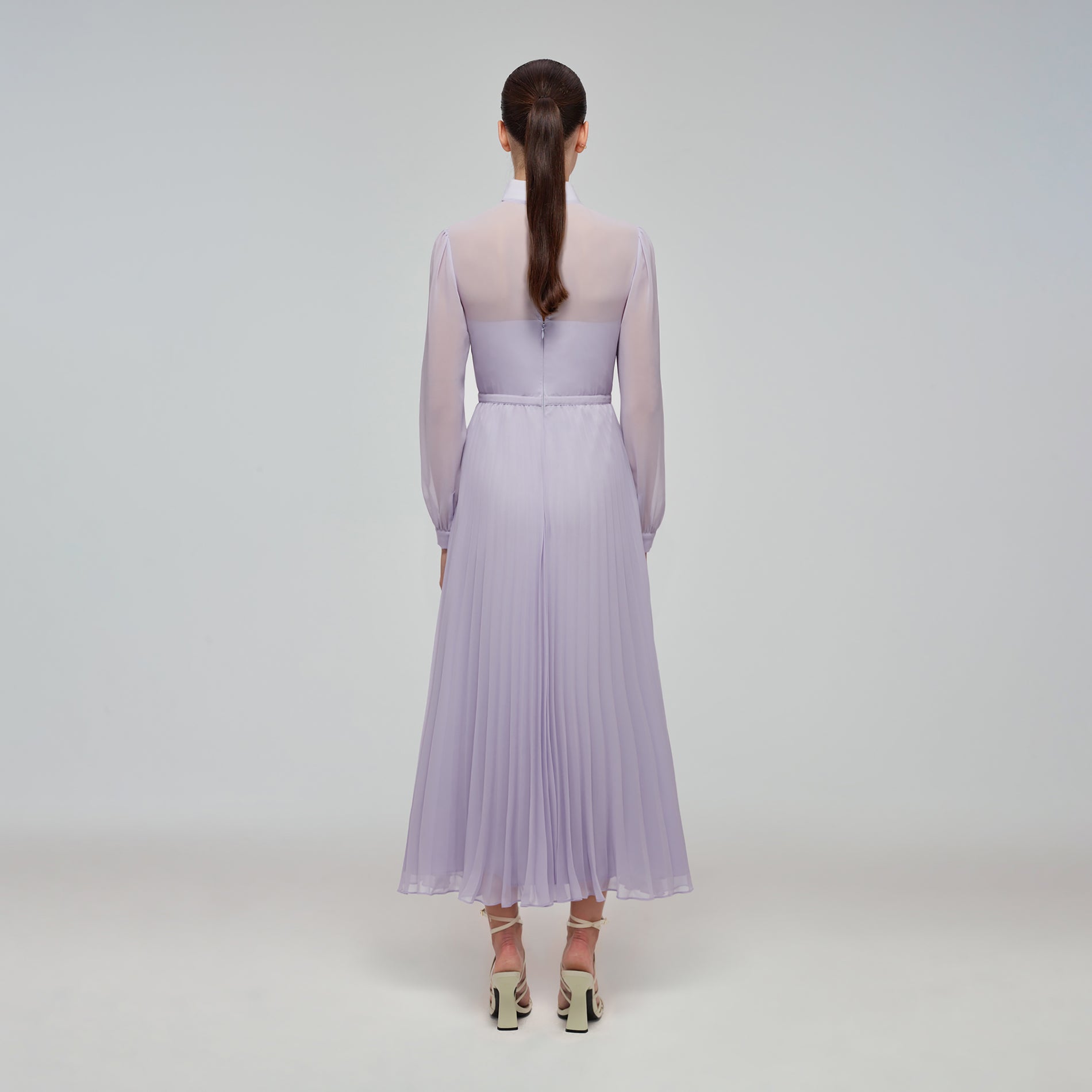 A woman wearing the Lilac Chiffon Pussy Bow Dress