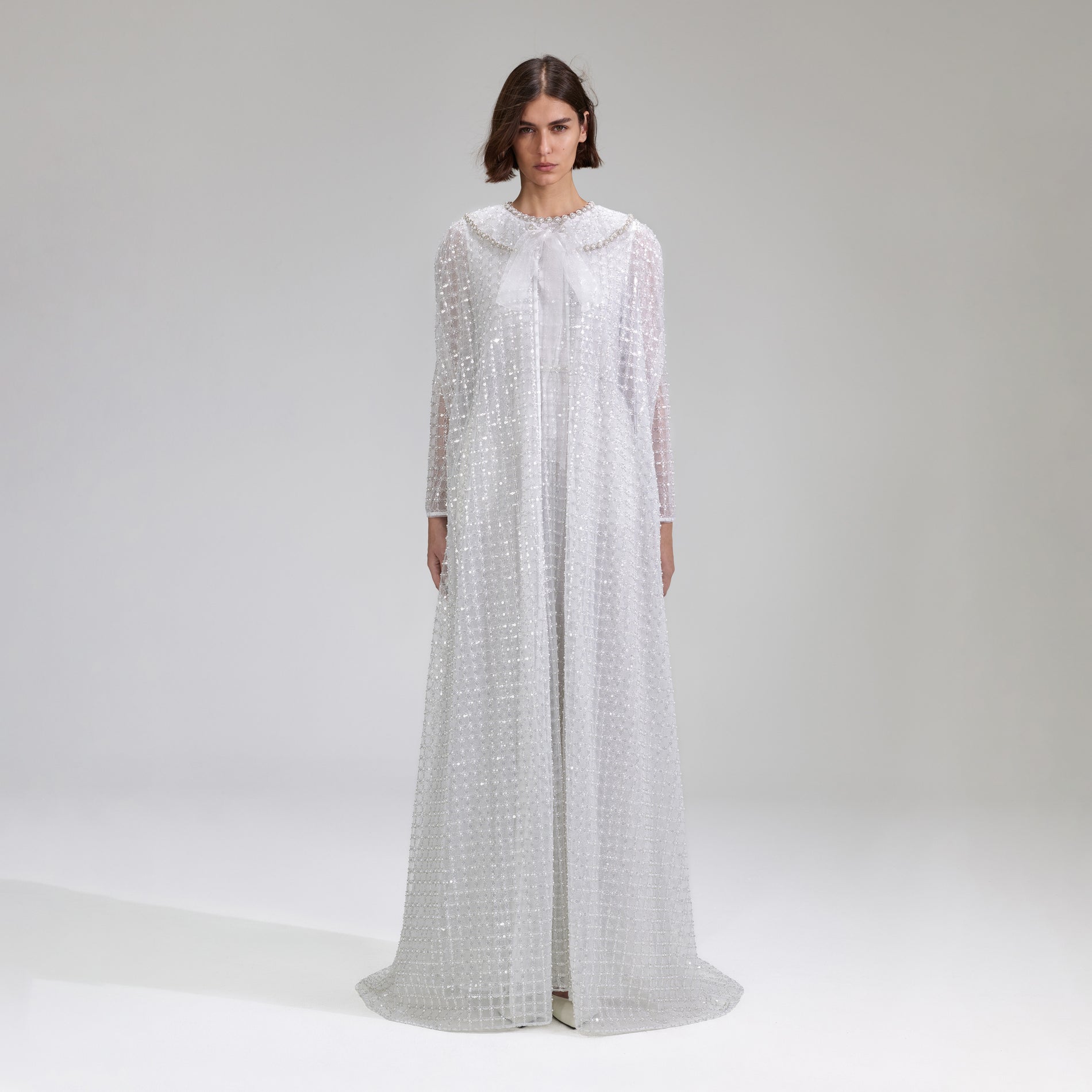 A woman wearing the White Grid Sequin Maxi Cape